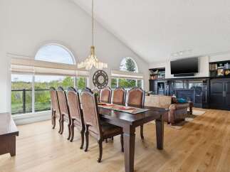 Experience elegant dining in this spacious room, featuring a grand dining table with seating for eight and a stunning crystal chandelier overhead.