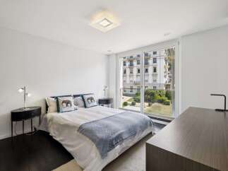 Experience modern comfort in this beautifully appointed bedroom, featuring a plush bed adorned with decorative elephant-themed pillows and a cozy chevron-patterned throw.