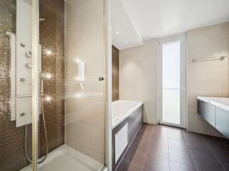 Experience modern luxury in this stunning bathroom featuring a sleek shower enclosure with a multi-jet system and a deep soaking tub.