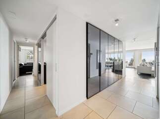 Step into this elegant hallway featuring a sleek mirrored wardrobe and a bright, airy ambiance.