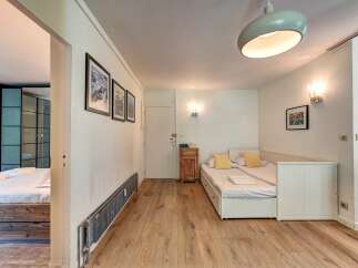 This charming studio apartment features a versatile sleeping area with two twin beds that can be combined into a larger sleeping space.