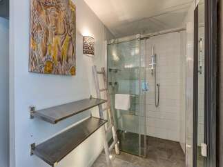 Experience a spa-like retreat in this modern bathroom, featuring a spacious glass-enclosed shower with sleek chrome fixtures.
