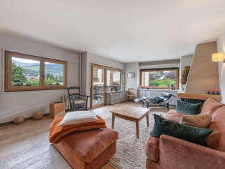 Experience breathtaking mountain views from this charming living room, featuring a cozy fireplace and ample natural light.