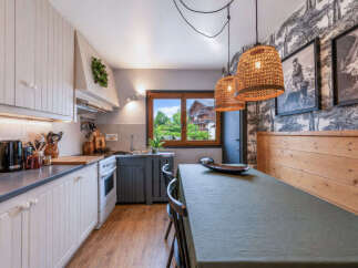 Charming kitchen and dining area featuring rustic wooden accents and a large window with scenic views.