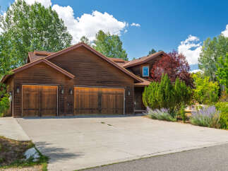 Discover this charming wooden home featuring a spacious three-car garage, perfect for car enthusiasts or extra storage needs.
