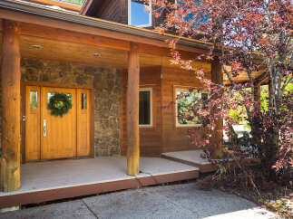Experience rustic charm with this inviting home featuring a natural stone facade and warm wooden accents.