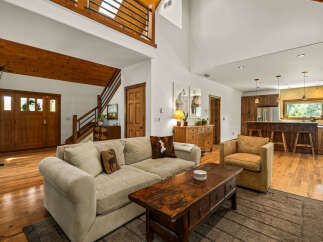 Experience rustic charm in this spacious living area featuring a cozy sectional sofa and a rustic coffee table, perfect for gatherings.
