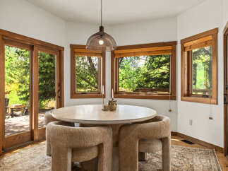 This dining area features a round stone-top table with plush, textured chairs, perfect for intimate gatherings.