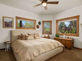 Experience rustic charm in this inviting bedroom, featuring a plush, upholstered bed as the centerpiece.