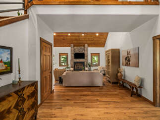 Step into this inviting entryway featuring a stunning stone fireplace as the focal point of the living area.