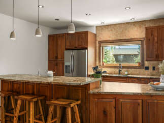 Experience rustic charm in this spacious kitchen, featuring custom wood cabinetry and a large granite island perfect for entertaining.