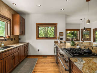 This spacious kitchen boasts custom wood cabinetry and stunning granite countertops, perfect for any home chef.
