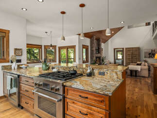 Experience rustic charm and modern convenience in this stunning kitchen, featuring a professional-grade gas range and a spacious granite island perfect for meal prep and entertaining.