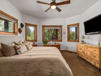 Experience rustic charm in this inviting bedroom, featuring a comfortable king-sized bed adorned with plush pillows and a textured headboard.