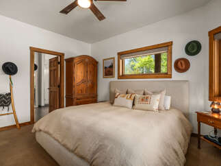 This charming bedroom features a cozy king-size bed with plush bedding and decorative pillows, perfect for a restful night's sleep.