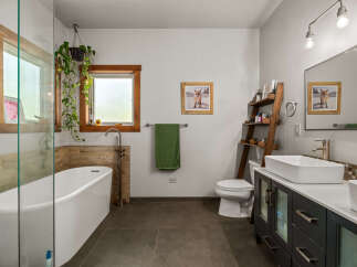 This modern bathroom features a freestanding soaking tub with a glass enclosure, perfect for a spa-like experience at home.