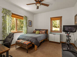 This bedroom offers a comfortable and functional space, featuring a cozy bed with plush pillows and a decorative bench at its foot.