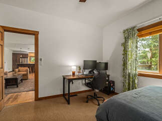 This inviting bedroom offers a dedicated workspace with dual monitors and a comfortable office chair, perfect for remote work or study.