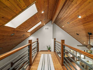 Experience the warmth and natural beauty of this home, featuring a stunning wood-paneled vaulted ceiling with skylights that flood the space with natural light.