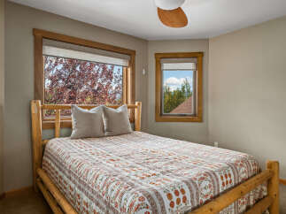Experience cozy comfort in this charming bedroom, featuring a rustic log bed and a beautiful quilt.