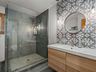 Experience modern luxury in this stunning bathroom featuring a spacious glass-enclosed shower with sleek tilework.