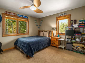 This cozy bedroom features a comfortable queen-size bed with a navy blue comforter, perfect for a restful night's sleep.