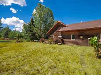 Discover this charming wooden home nestled amidst lush greenery and mature trees, offering a serene and private retreat.