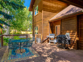 Enjoy outdoor living on this spacious wooden deck, perfect for entertaining or relaxing amidst lush greenery.