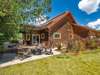 Enjoy the serene mountain lifestyle with this charming log home, featuring a spacious wooden deck perfect for outdoor entertaining and relaxation.