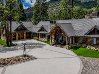 Experience luxury mountain living in this stunning log and stone home, nestled amidst towering pines and majestic mountains.