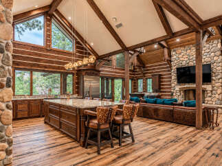 Experience luxurious mountain living in this stunning log home, featuring a gourmet kitchen with a large island and granite countertops.