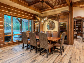 Experience rustic elegance in this stunning dining room, featuring a live-edge wood table and plush upholstered chairs perfect for hosting.