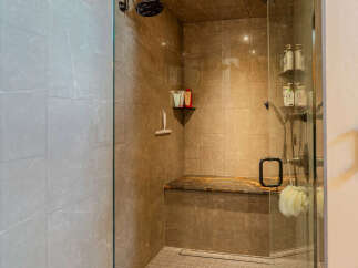 Experience luxury in this modern bathroom featuring a spacious walk-in shower with elegant marble tilework.