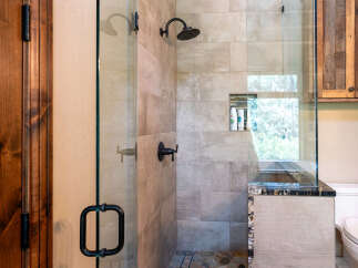Experience luxury in this modern bathroom featuring a spacious walk-in shower with elegant tile work and a built-in niche for toiletries.