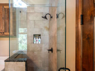 Experience luxury in this master bathroom featuring a spacious walk-in shower with elegant tile work and a built-in niche for toiletries.