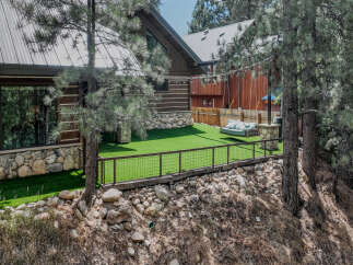 Experience the ultimate mountain retreat with this stunning log cabin featuring a modern metal roof and expansive windows.