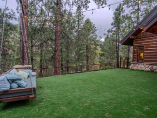 Experience outdoor living at its finest with this charming log cabin featuring a spacious, artificial turf backyard perfect for relaxation and entertaining.