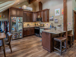 Discover this charming kitchen featuring rich, dark wood cabinetry and a spacious stainless steel refrigerator adorned with personal mementos.