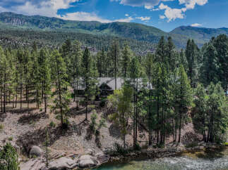 Nestled amidst a dense pine forest, this rustic log cabin offers a serene retreat with breathtaking mountain views.