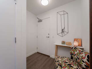 Step into this welcoming entryway featuring a sleek white door with modern hardware.