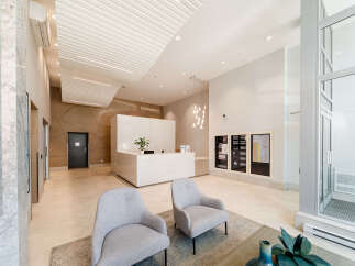 Experience a warm welcome in this modern lobby featuring a sleek marble reception desk and comfortable seating areas.