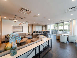 Experience modern living in this spacious lounge area, featuring a comfortable sectional sofa, a stylish coffee table, and a sleek entertainment unit with a fireplace.