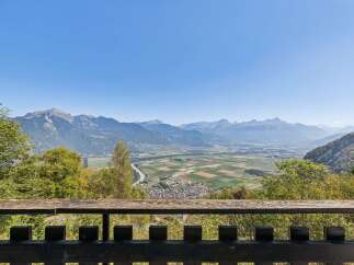 Experience breathtaking panoramic views from this stunning property, overlooking a lush valley and majestic mountains.
