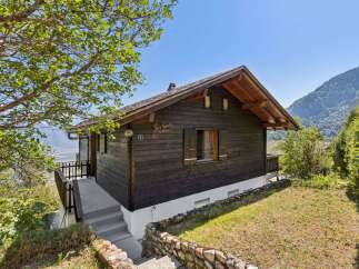 Nestled amidst breathtaking mountain scenery, this charming wooden chalet offers a serene escape.