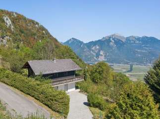 Nestled amidst lush greenery, this charming mountain home offers breathtaking panoramic views of the valley and majestic peaks.