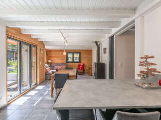 Experience cozy living in this charming wooden cabin featuring a spacious open-plan living and dining area.