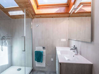 Experience modern comfort in this stylish bathroom, featuring a sleek glass-enclosed shower and a spacious vanity with a contemporary faucet.