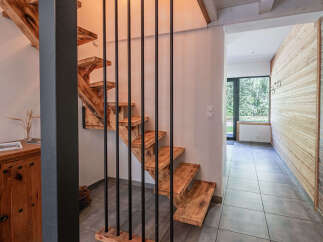 Discover this stunning home featuring a unique wooden staircase with black metal railings, creating a modern yet rustic aesthetic.