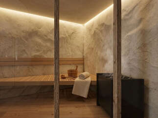 Experience ultimate relaxation in this luxurious sauna, featuring natural stone walls and warm wood accents.