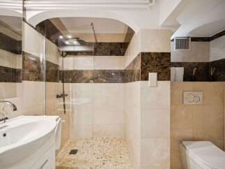 Experience modern luxury in this beautifully appointed bathroom, featuring a spacious walk-in shower with elegant marble accents and a sleek glass enclosure.